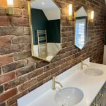 Brushed_brass_hexogon_Bathroom_Mirrors_Fitted_on_brick_wall